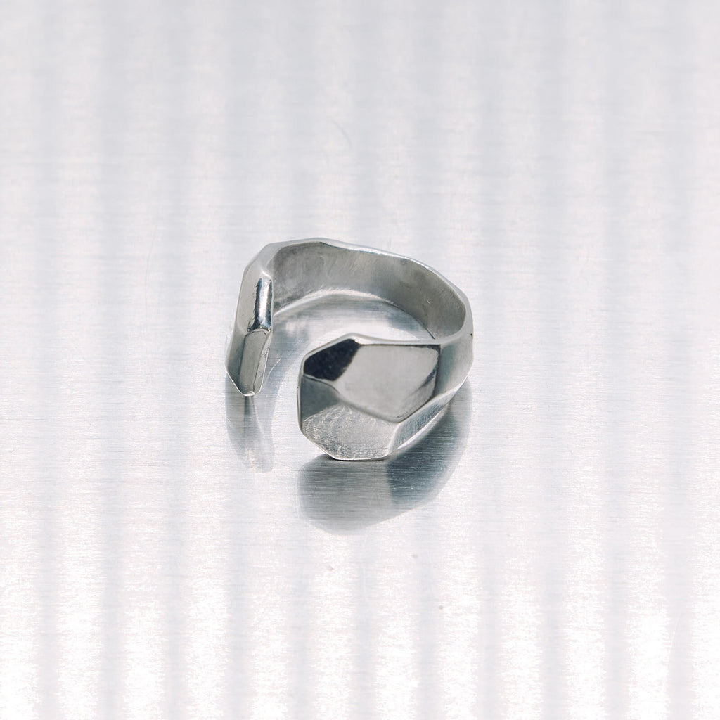 Silver ring with geometric design on a white background