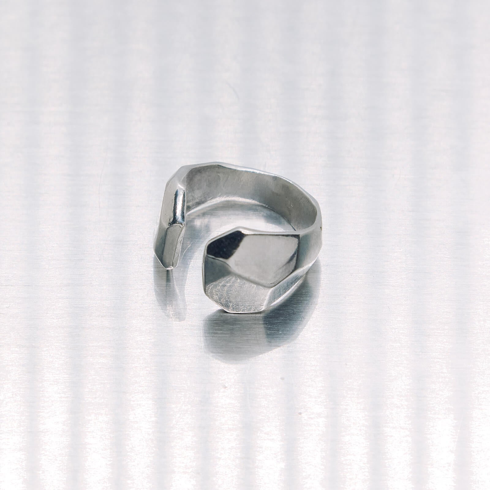 Silver ring with geometric design on a white background