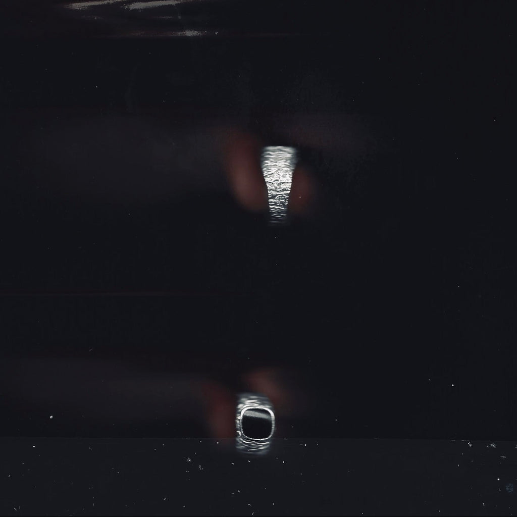 Three rings displayed on a reflective black surface
