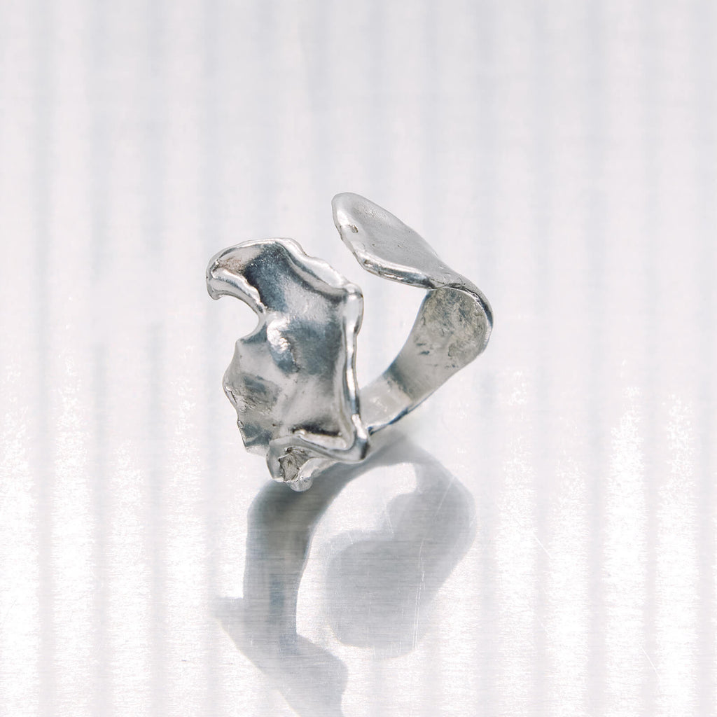 Silver ring with a unique design on a white background