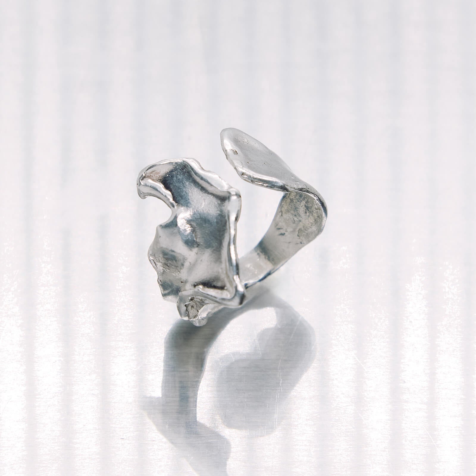 Silver ring with a unique design on a white background