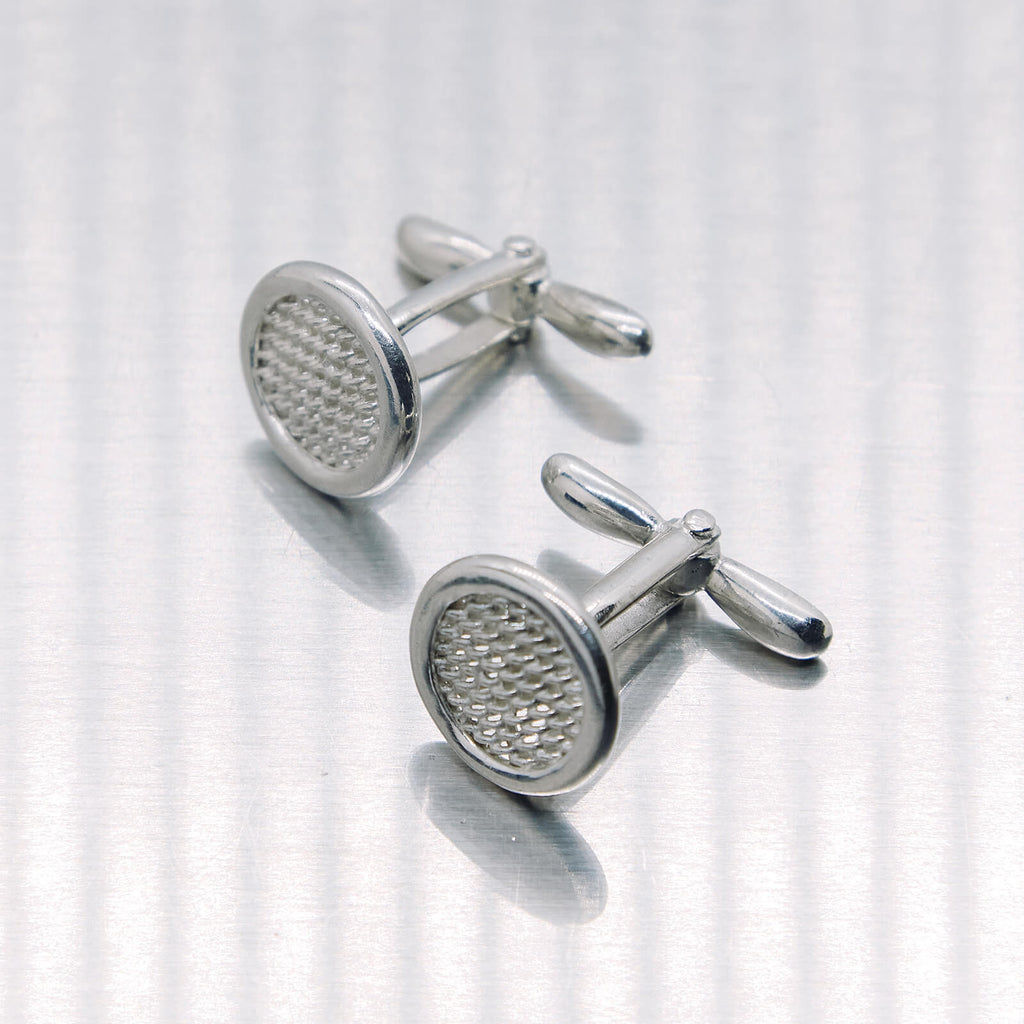 Pair of silver cufflinks on a white background