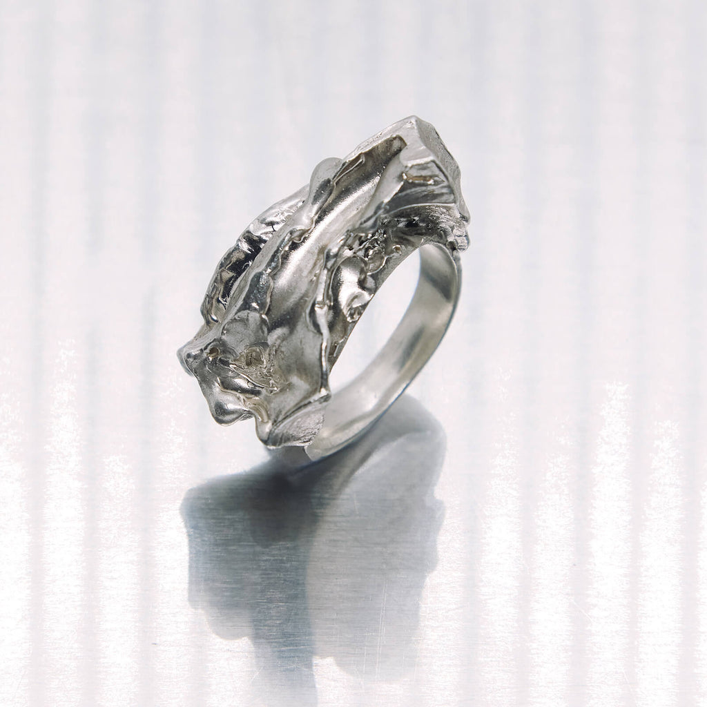 Silver ring with a textured design on a white background