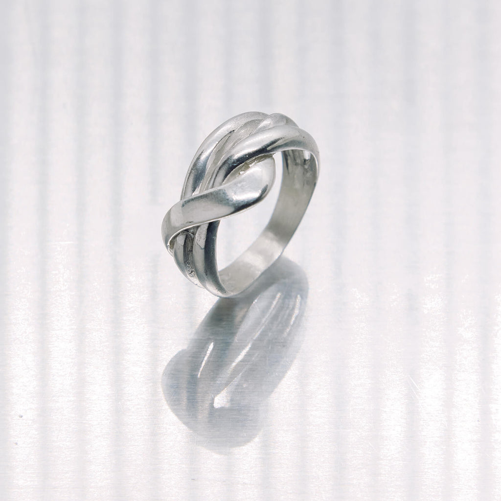 Silver ring with a knot design on a white background