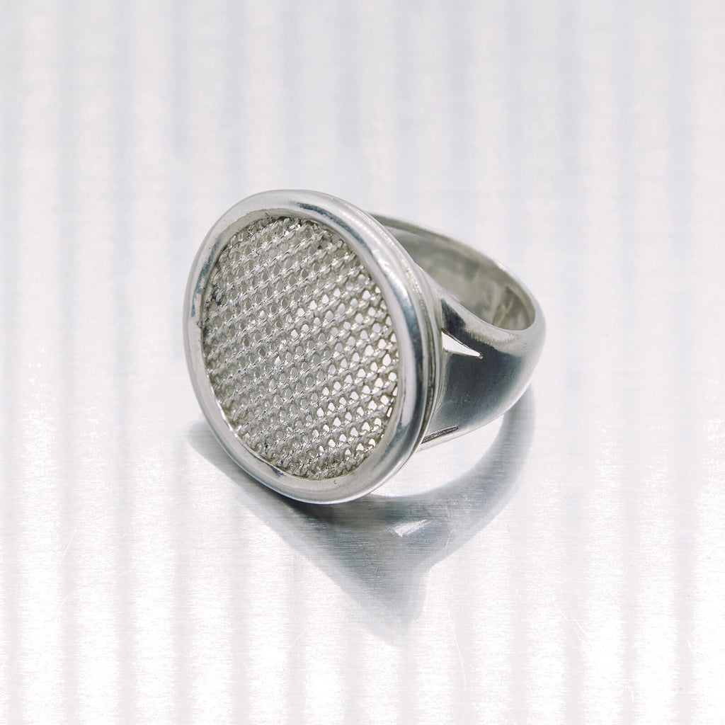 Silver ring with textured design on a white background
