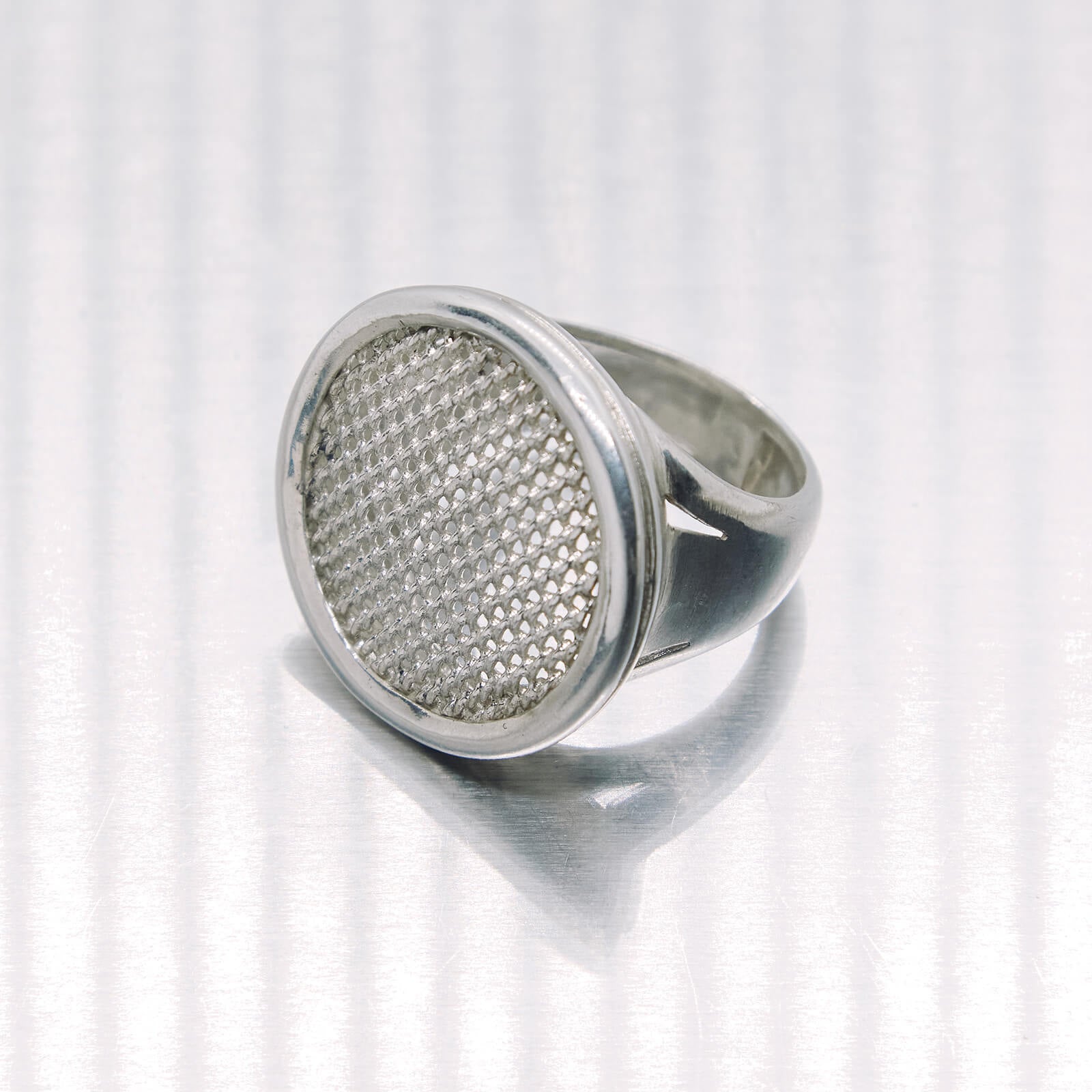 Silver ring with textured design on a white background
