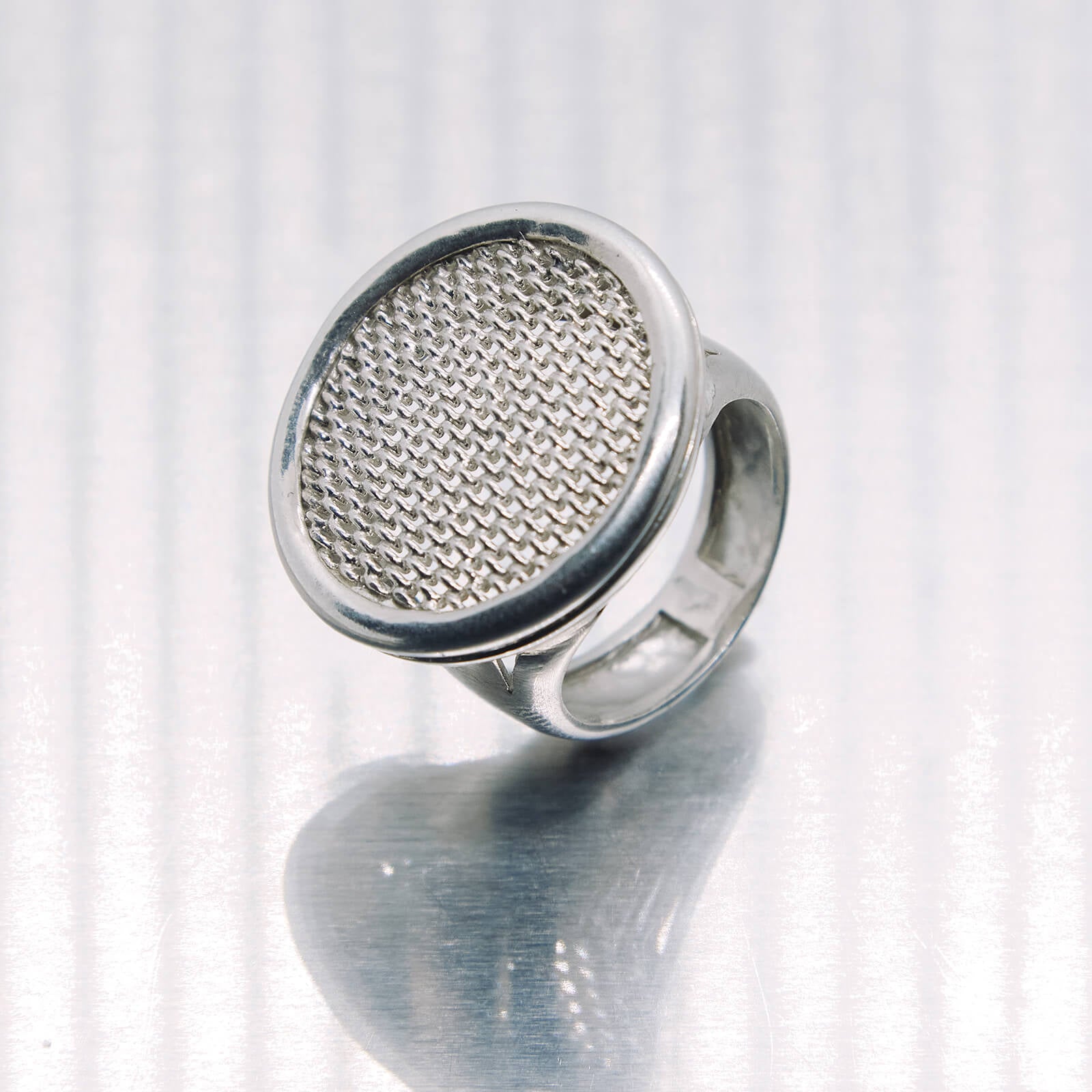 Silver ring with textured design on a white background