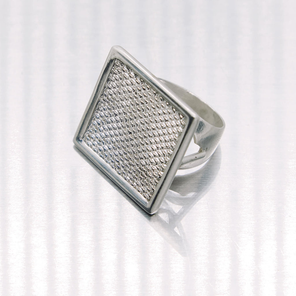 Silver ring with textured design on a white background