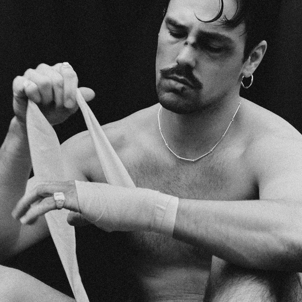 Man preparing for a fight with boxing gloves and a rope, black and white photo