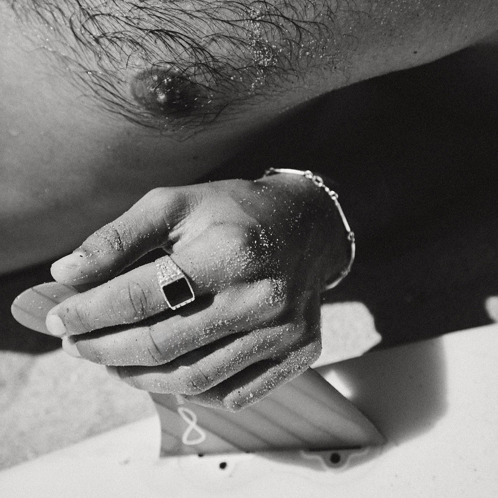 Close-up of a person's hand with a ring on a blurred background