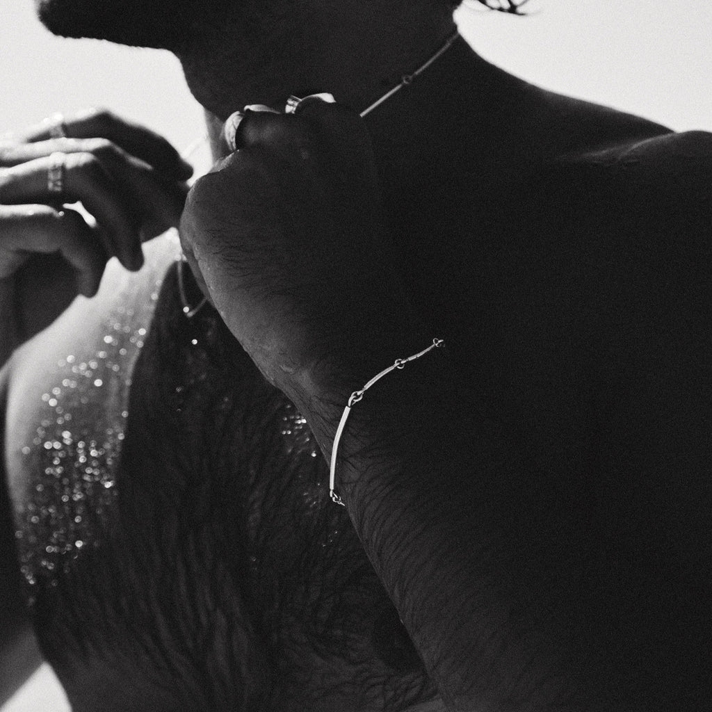 Black and white close-up of a person wearing jewelry with a blurred background