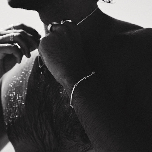 Black and white close-up of a person wearing jewelry with a blurred background